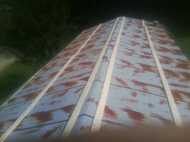 Rusted metal roof panels with new wood purlins before replacement — Storm Damage Roof Repair in Arena by Roofing Brothers