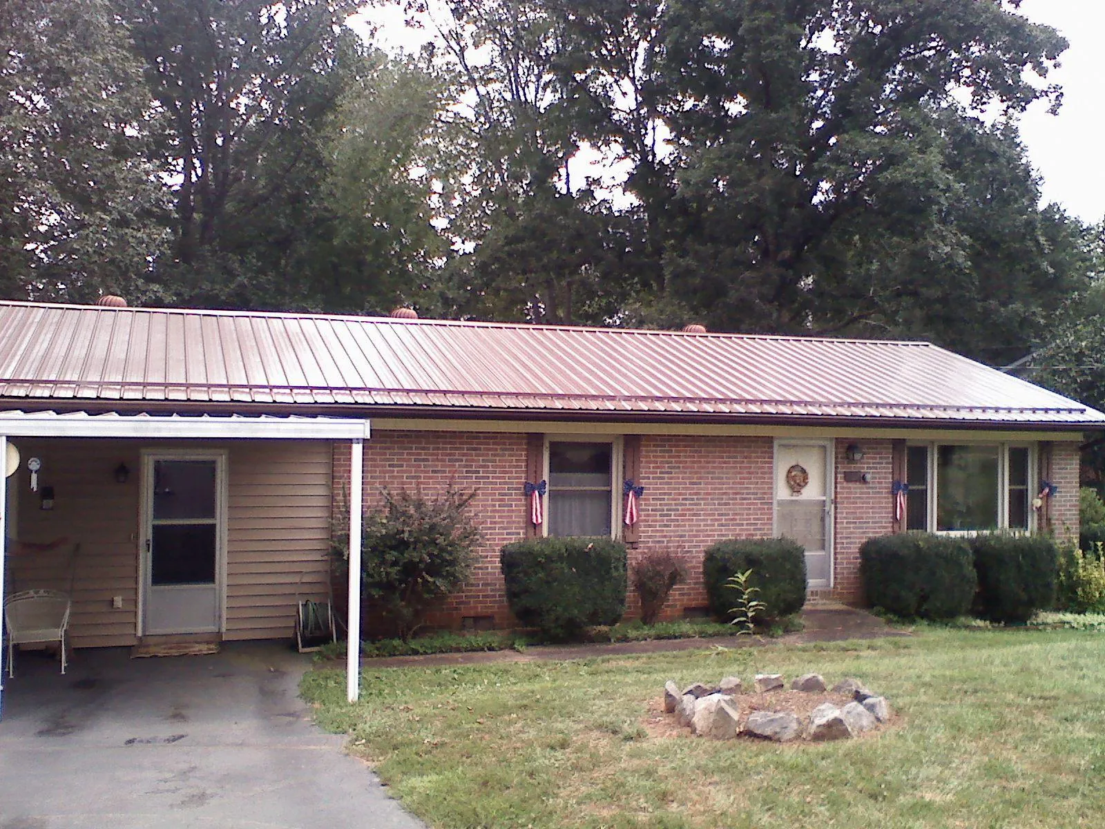 Bronze metal roof and carport on a brick ranch home — Roof Repair work by our crew in Arena